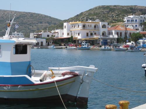 a boat is docked in a harbor with houses at Calypso Hotel in Lipsoi