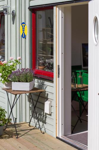 a porch with a table with flowers and a window at STF Svartsö Skärgårdshotell & Vandrarhem in Svartsö