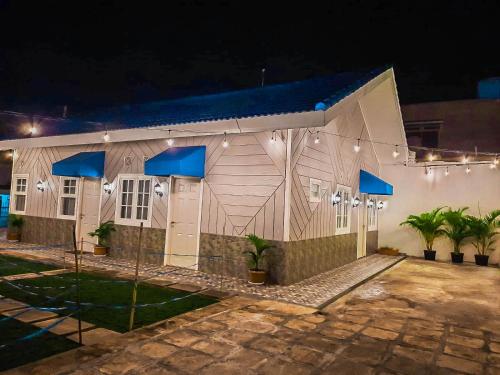 duży biały budynek z niebieskim dachem w nocy w obiekcie Rosemary Homestay w mieście Batu