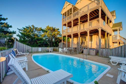 a house with a swimming pool next to a building at Make My Day 710 in Avon