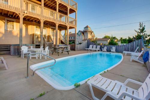 a swimming pool with white chairs and a house at Make My Day 710 in Avon