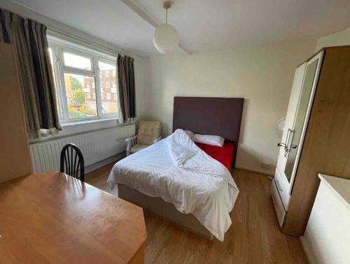 een kleine slaapkamer met een bed en een tafel bij Arbnb Comfy Sleep Guest House Self Catering Private Bedrooms 60 pound per night per person in Londen