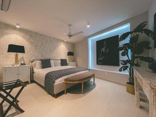 a bedroom with a bed and a tv on the wall at Hotel Boutique Casa Hendaus - Adults Only in San Andrés