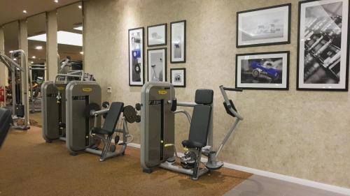 a gym with a row of exercise equipment on a wall at MCity Jalan Ampang KLCC in Kuala Lumpur