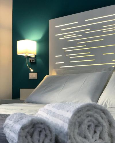 sypialnia z białym łóżkiem z lampką na ścianie w obiekcie B&B Angolo83 Palermo centro w mieście Palermo
