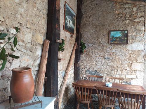 une table et des chaises en bois dans un mur en pierre dans l'établissement Maison Berrichonne 2 chambres cour et jardin, à Saint-Marcel