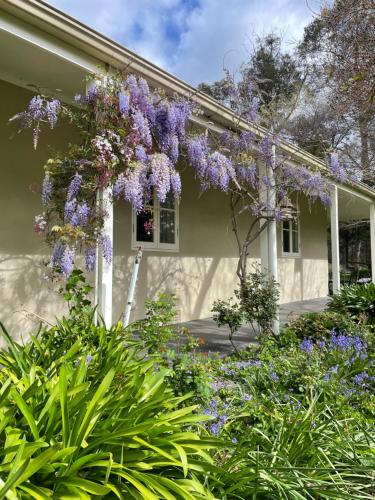 a house with a wreath of purple flowers on it at Fleetwood Cottage Bed and Breakfast in Mylor