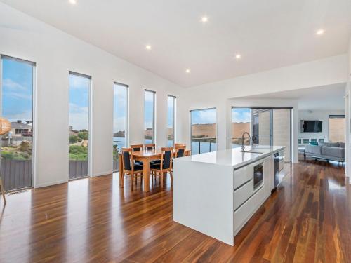 an open kitchen and dining room with a table and chairs at River Reveal in Warrnambool