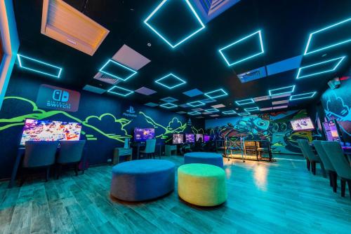 a room with a video game screen and chairs at Grand Cosmos Resort Ruisui Hualien in Ruisui