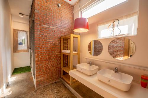 a bathroom with two sinks and a brick wall at 高雄駁二迴埕Return Trip in Kaohsiung