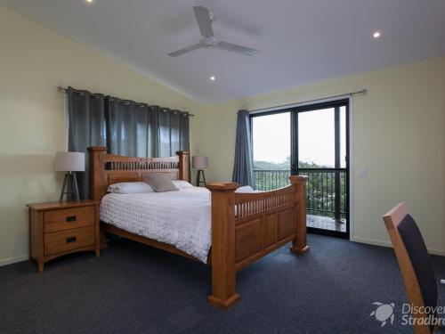 a bedroom with a bed and a large window at Colours of Cylinder in Point Lookout