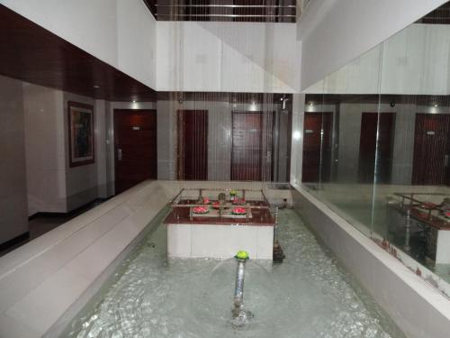 una piscina de agua en un edificio con una bola dentro en Lotus Comfort - A Pondy Hotel en Pondicherry