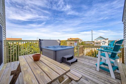 a deck with a wooden table and a blue chair at Feelin' Nauti 866 in Waves