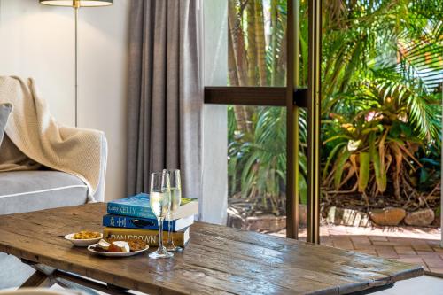 a wooden table with a glass of wine and books at The Noosa Apartments in Noosa Heads