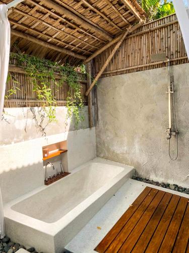 a bath tub in a room with a wooden floor at Mimi House in Hoi An