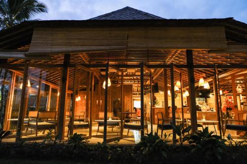 a restaurant with a wooden pavilion with chairs and tables at Teras Hotel Ijen Banyuwangi in Banyuwangi