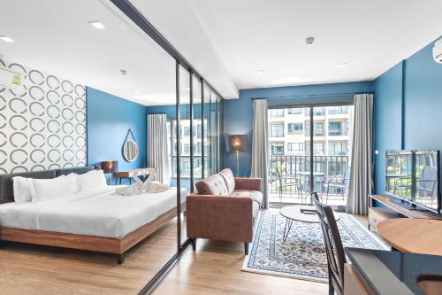 um quarto com paredes azuis, uma cama e uma mesa em Rain Cha Am - Hua Hin by J&P em Cha Am
