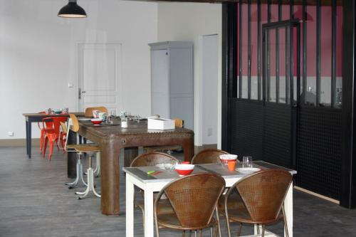 un groupe de tables et de chaises dans une pièce dans l'établissement Les Tournelles - Chambres d'hôtes, à Saint-Mesmes