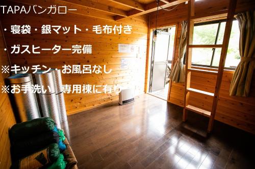 a room with a wooden wall with writing on it at Asian Camp Resort TAPA in Minakami