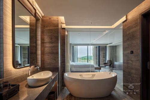 a bathroom with two sinks and a large mirror at Runaway Cow Winery Retreat in Yantai