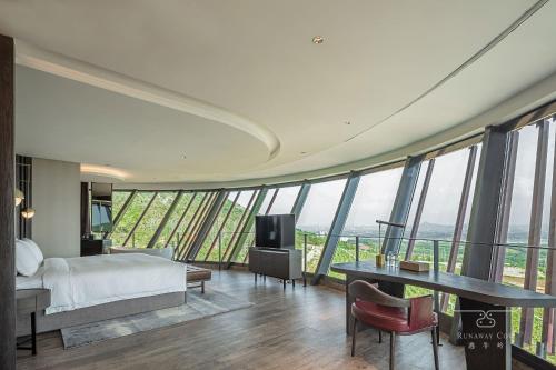 a bedroom with a bed and a desk and a tv at Runaway Cow Winery Retreat in Yantai