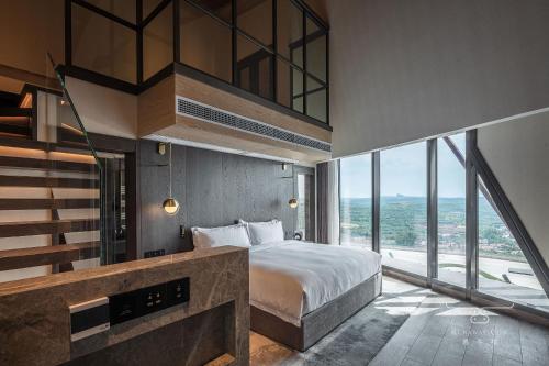 a bedroom with a bed and a large window at Runaway Cow Winery Retreat in Yantai