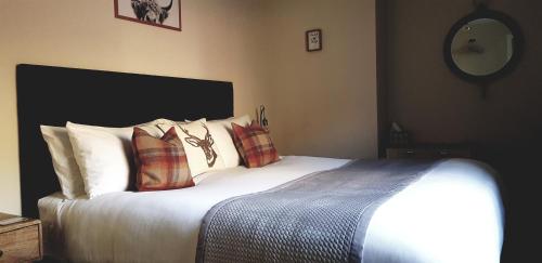 a bedroom with a large bed with pillows on it at Airanloch, Loch Ness, Adult Only in Lochend