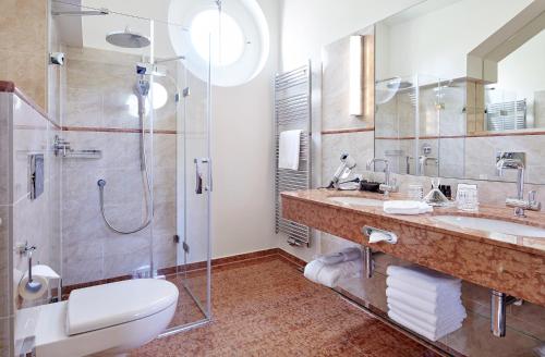 a bathroom with a toilet and a sink and a shower at Relais & Chateaux Hotel Hohenhaus in Herleshausen