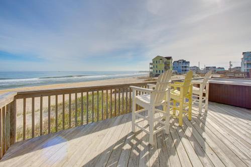 two chairs sitting on a deck looking at the beach at Captain's Quarters 125 in Rodanthe