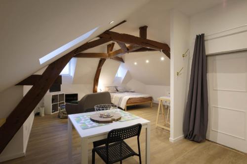 Zimmer mit einem Bett und einem Tisch sowie einem Schlafzimmer in der Unterkunft Studio neuf cosy La flèche in La Flèche