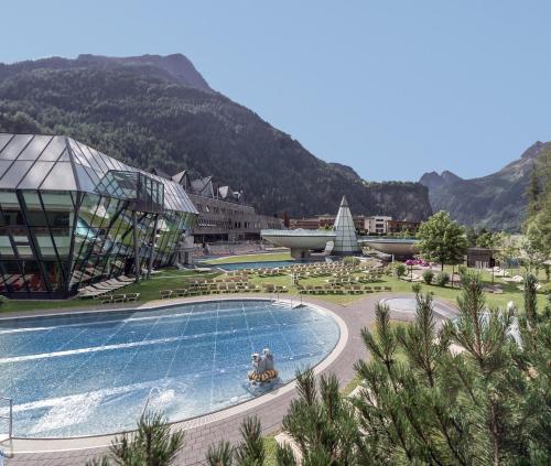 a resort with a large swimming pool and a building at Aqua Dome 4 Sterne Superior Hotel & Tirol Therme Längenfeld in Längenfeld
