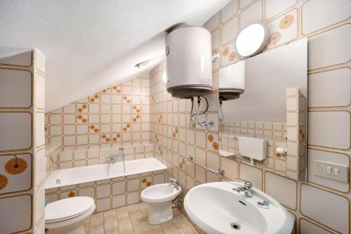 Un baño con lavabo, inodoro y espejo. en Villa Paola Bilo4 Bis, en Loano