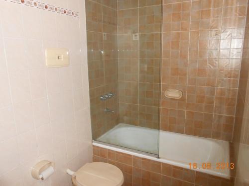 a bathroom with a shower and a toilet and a tub at Casablanca in Victoria