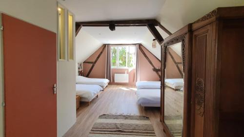 una camera mansardata con 3 letti e una finestra di Week-End au Vert a Voisines