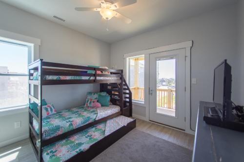 a bedroom with two bunk beds and a balcony at The Knotty Whale 120 in Rodanthe