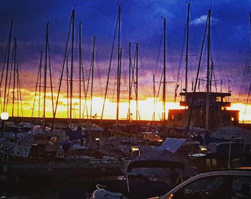 een groep boten geparkeerd in een jachthaven bij zonsondergang bij La Cabina in Chiavari