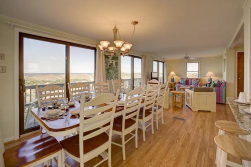Un comedor con mesa y sillas y una sala de estar. en Carolina House 80, en Avon