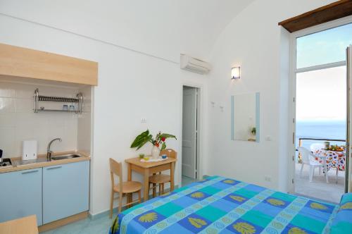 1 dormitorio con 1 cama, cocina y mesa en Da Rita en Amalfi