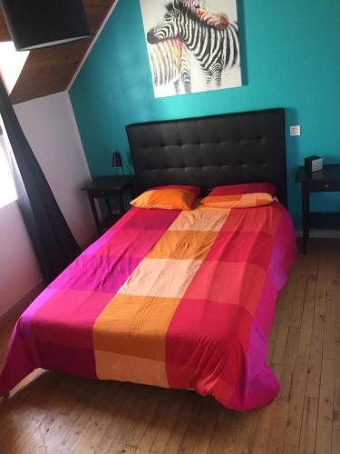 Una cama con una manta de colores encima. en Gîte à la campagne, en Pontchâteau