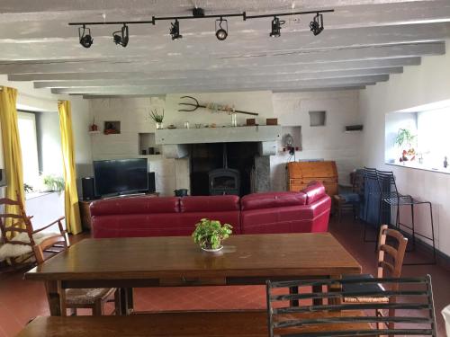 sala de estar con sofá rojo y mesa en Gîte à la campagne, en Pontchâteau