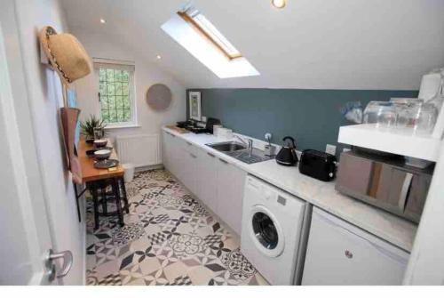 a kitchen with a sink and a washing machine at Treetops in Coleraine