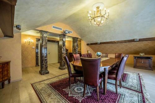 a dining room with a table and chairs and a chandelier at Imperial Hotel & Restaurant in Vilnius