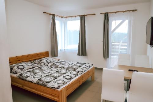 a bedroom with a bed and a table and chairs at Chaty a Apartmány Hracholusky Kemp Kosatka in Pňovany
