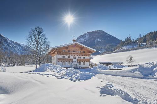 a building covered in snow next to a snow covered road at Wieslbauer in Flachau