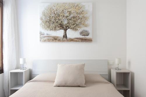 une chambre blanche avec une peinture sur les arbres sur le mur dans l'établissement Palazzina San Polo 2151, à Venise