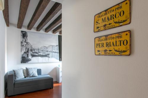 a living room with a couch and signs on the wall at Palazzina San Polo 2151 in Venice