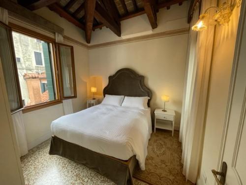 ヴェネツィアにあるSan Gregorio Venice Apartmentsの大きなベッドと窓のある寝室