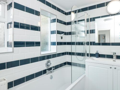 a bathroom with a shower and a tub and a sink at Hillside in Dartmouth