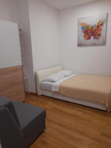 a bedroom with a bed and a butterfly painting on the wall at Apartmani Belvedere in Novigrad Istria