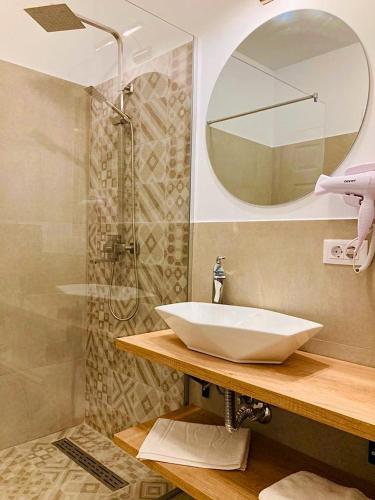 a bathroom with a white sink and a shower at PENSIUNEA SUGAG in Şugag